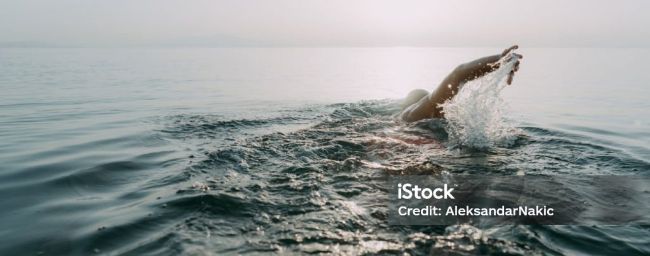 Photo of a young man who is having daily swim training in the sea